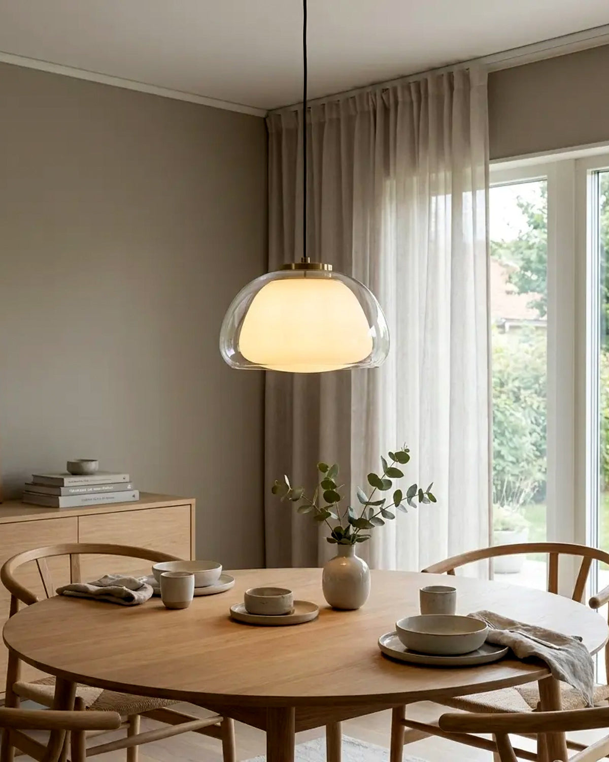 Lámpara colgante de vidrio y difusor dorado en comedor luminoso