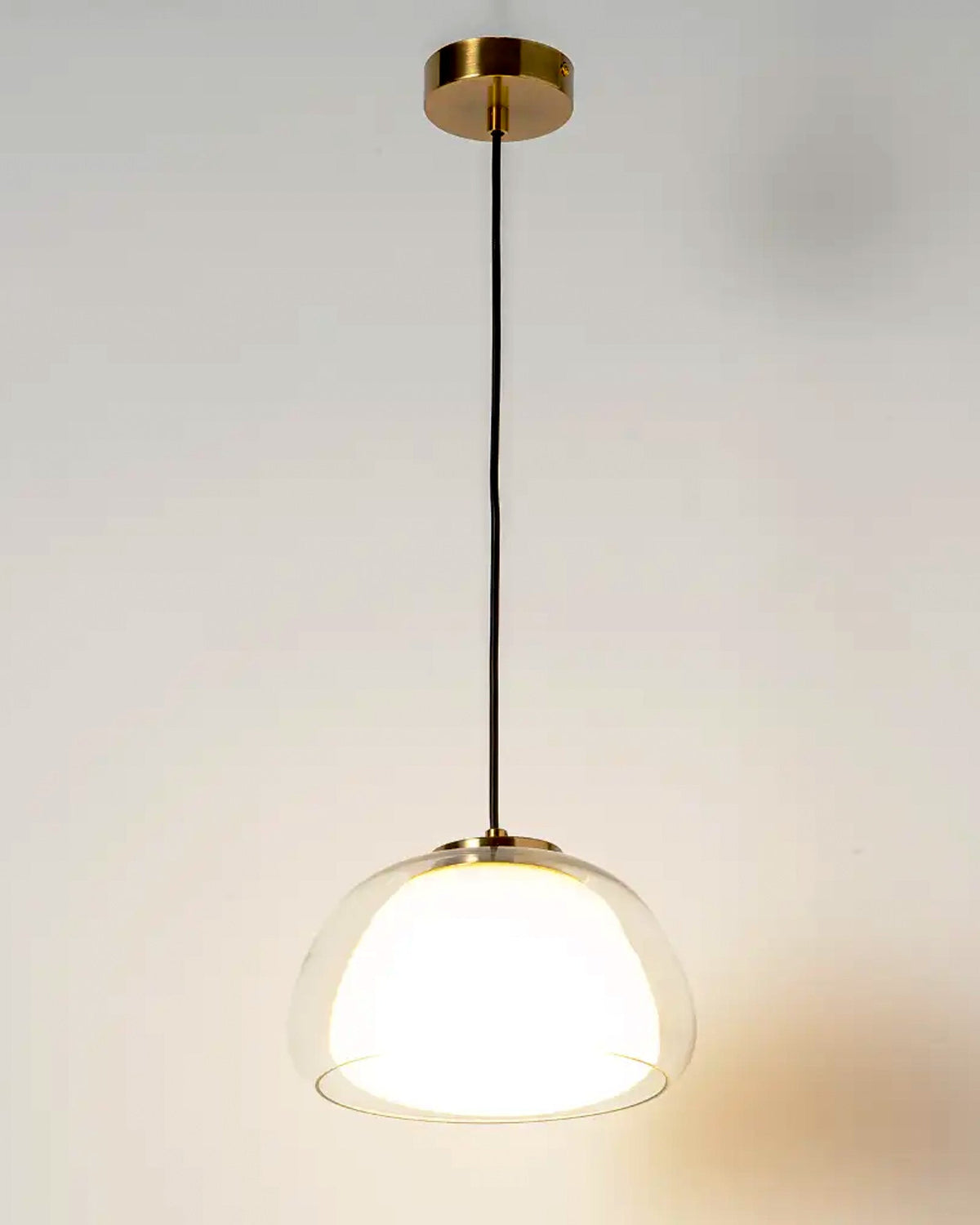 Lámpara colgante de vidrio transparente con difusor metálico dorado